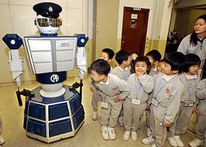 Estudiantes de entre tres y cuatro años escuchan las explicaciones mientras observan con curiosidad a &#39;Robotcop&#39;.