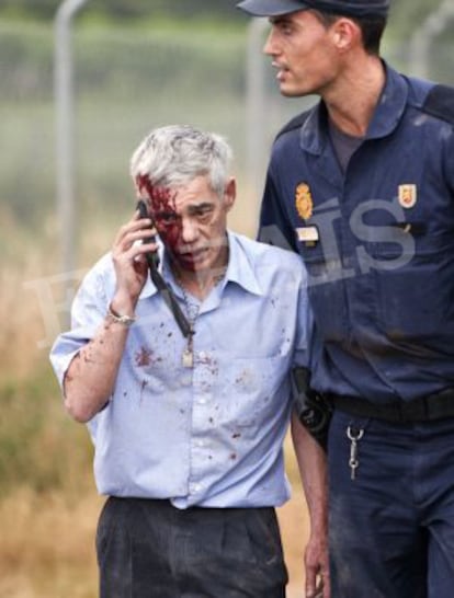 El maquinista del tren de Santiago, escoltado por un policía, tras el accidente.