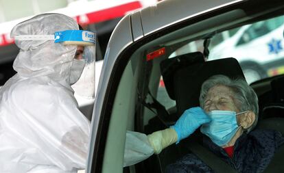 Una sanitaria protegida con EPI toma una muestra para una prueba PCR frente al hospital de Gandía este viernes.