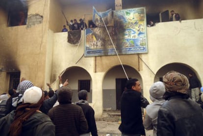 Manifestantes descuelgan un cartel de un edificio oficial durante una protesta en la ciudad costera de Tobruk, en la región de la Cirenaica.