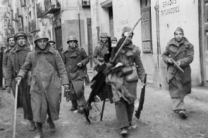 Teruel, 7 de enero de 1938. Soldados del Ejército Popular entran en la ciudad, retirando de los edificios conquistados las banderas del enemigo.