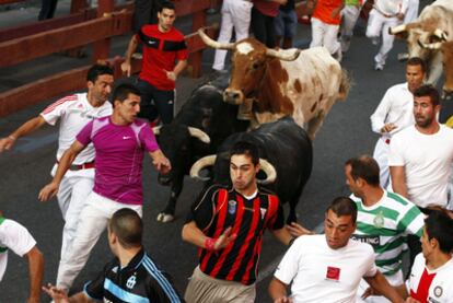 Un grupo de corredores, delante de los toros de los encierros de San Sebastián de los Reyes.