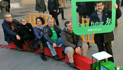 Jordi Sánchez, líder de la ANC, de pie, posa con una ventana con el lema Fem futur.