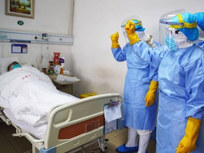 Miembros del personal médico animan a un paciente infectado por el coronavirus en una sala de aislamiento en un hospital de Zouping, en la provincia china de Shandong, el pasado martes.