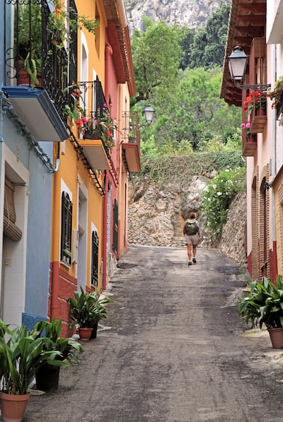 Una mujer callejeando por el pueblo de Benimaurell.