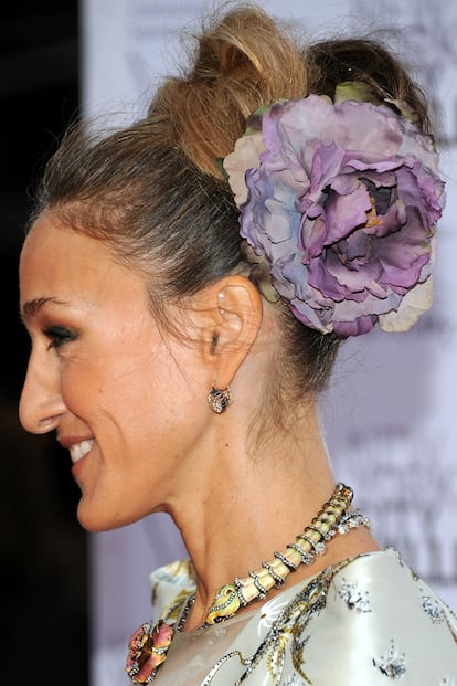 El moño alto también es todo un clásico en Sarah Jessica Parker, aunque la actriz lo suele decorar con maxi flores.