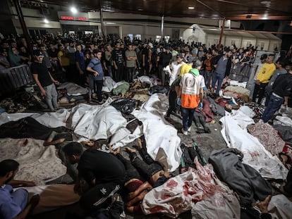 Los cuerpos de las víctimas del ataque junto al hospital Al Ahli de Gaza son depositados a la puerta del centro sanitario, este martes.