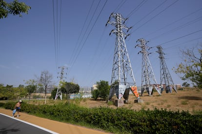 Un hombre camina junto a las torres eléctricas de una subestación eléctrica de Madrid, este miércoles.