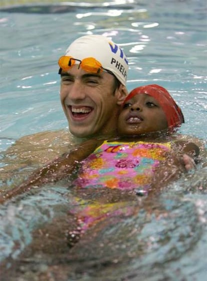 Michael Phelps participa en un programa para enseñar a nadar a niños ayer en Nueva York.