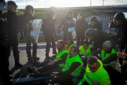 Agentes antidisturbios hablan con un grupo de agricultores que han cortado la A-42 a la altura de Torrejón de la Calzada (Madrid). 