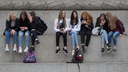 Varias adolescentes usan sus teléfonos móviles en Londres, en mayo de 2019.