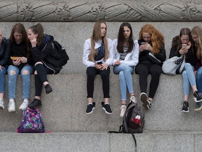 Varias adolescentes usan sus teléfonos móviles en la Plaza Trafalgar de Londres, en mayo de 2019.