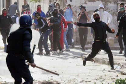 Un grupo de jóvenes se enfrenta a agentes de policía, ayer, en un barrio de Argel.