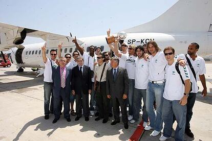 La plantilla de jugadores y el cuerpo técnico del Club Baloncesto Málaga posan en el aeropuerto a su llegada como campeones.