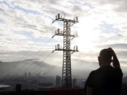 Una persona observa el cableado con el que Red Eléctrica transporta la energía sobre la ciudad de Bilbao.