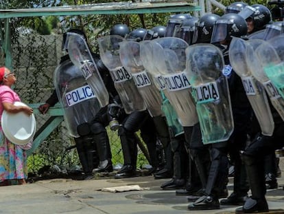 Una anciana habla con agentes antidisturbios para que la permitan acceder a su casa, el pasado día 19 en Managua.