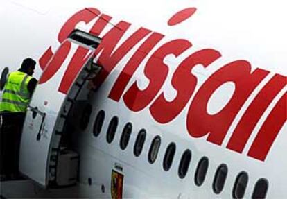 Un empleado de Swissair inspecciona uno de los aviones de la compañía que no despegó ayer de Zúrich.