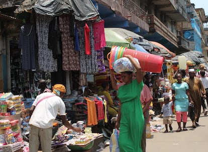 Un par de mujeres cargan solas sus compras en el mercado callejero de Malama Thomas Street, epicentro de la actividad económica en Freetown.