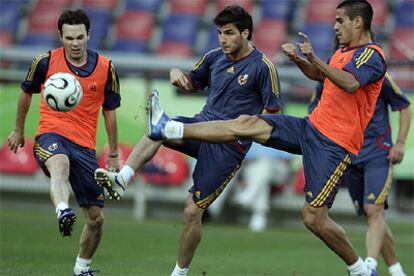 Cesc intenta zafarse de Iniesta y Juanito durante el partidillo de ayer.