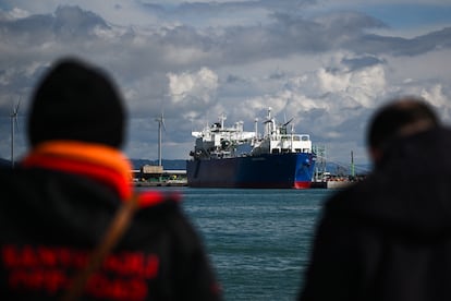 Varias personas observan la llegada de un buque cisterna de gas natural al puerto de Piombino.