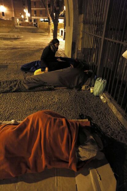 A volunteer from the NGO Solidarios para el Desarrollo talks with a homeless person.