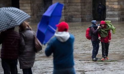 Varias personas se protegen de la lluvia en Santiago de Compostela.