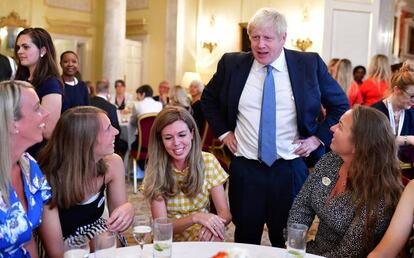 Carrie Symonds, con un vestido a cuadros amarillos, junto a su novio, el primer ministro británico Boris Johnson, el pasado 12 de agosto en Londres.