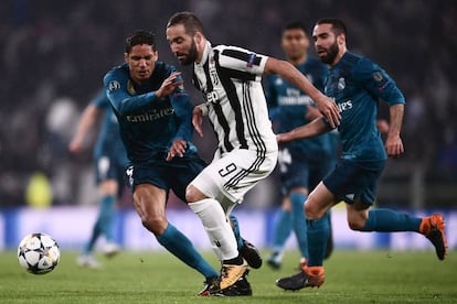 El delantero argentino de la Juventus Higuaín se lleva el balón ante Raphael Varane y Dani Carvajal, del Real Madrid.