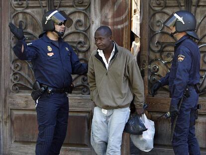 Uno de los inmigrantes que ocupaban la fábrica de Bombas Gens, en Valencia, abandona el edificio, desalojado por la policía.