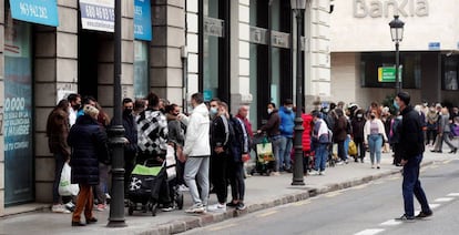 Ciudadanos esperando recibir comida de un banco de alimentos en el centro de Valencia. 