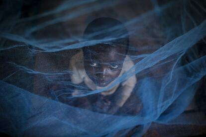 Un niño mira a través del quitamosquitos en un refugio organizado por la Agencia de Refugiados de las Naciones Unidas (UNHCR) en un centro de Gashora, a 55 kilómetros de Kigali (Ruanda).
