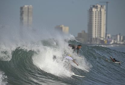 La gente surfea en la playa de Pinitos antes de que toque tierra la tormenta tropical 'Pamela', en Mazatlán, México.