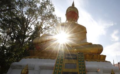 Estatua de Buda con una mascarilla en Tailandia.