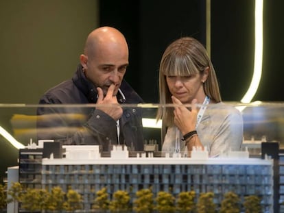 Dos visitantes al salón inmobiliario Barcelona Meeting Point (BMP) observan una maqueta.