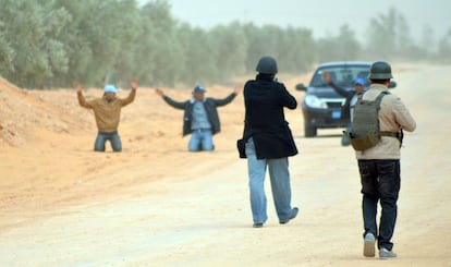 Polic&iacute;as tunecinos detienen a los pasajeros de un veh&iacute;culo que circulaba por una zona prohibida junto a la frontera libia, el 10 de marzo.