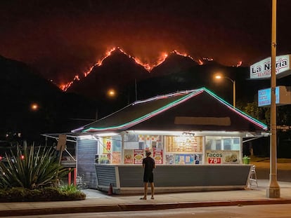 Posto de fast-food na cidade de Monrovia, na Califórnia, com um incêndio florestal ao fundo, na quinta-feira.