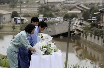 El primer ministro de Japón, Shinzo Abe (Derecho), el alcalde de Kurashiki Kaori Ito (al centro) y el gobernador de Okayama Ryuta Ibaragi (detrás), depositan flores en la zona de inundación Mabicho en Kurashiki, prefectura de Okayama.