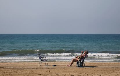 Una mujer toma el sol en una playa de Salou