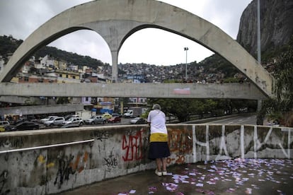 Vista da Rocinha, no Rio, no domingo: ao fundo, santinhos no chão e, ao fundo, a fila de eleitores aguardando para votar no primeiro turno.