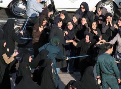 Varias agentes golpean a un grupo de feministas en una manifiestación por la igualdad de derechos en Teherán.