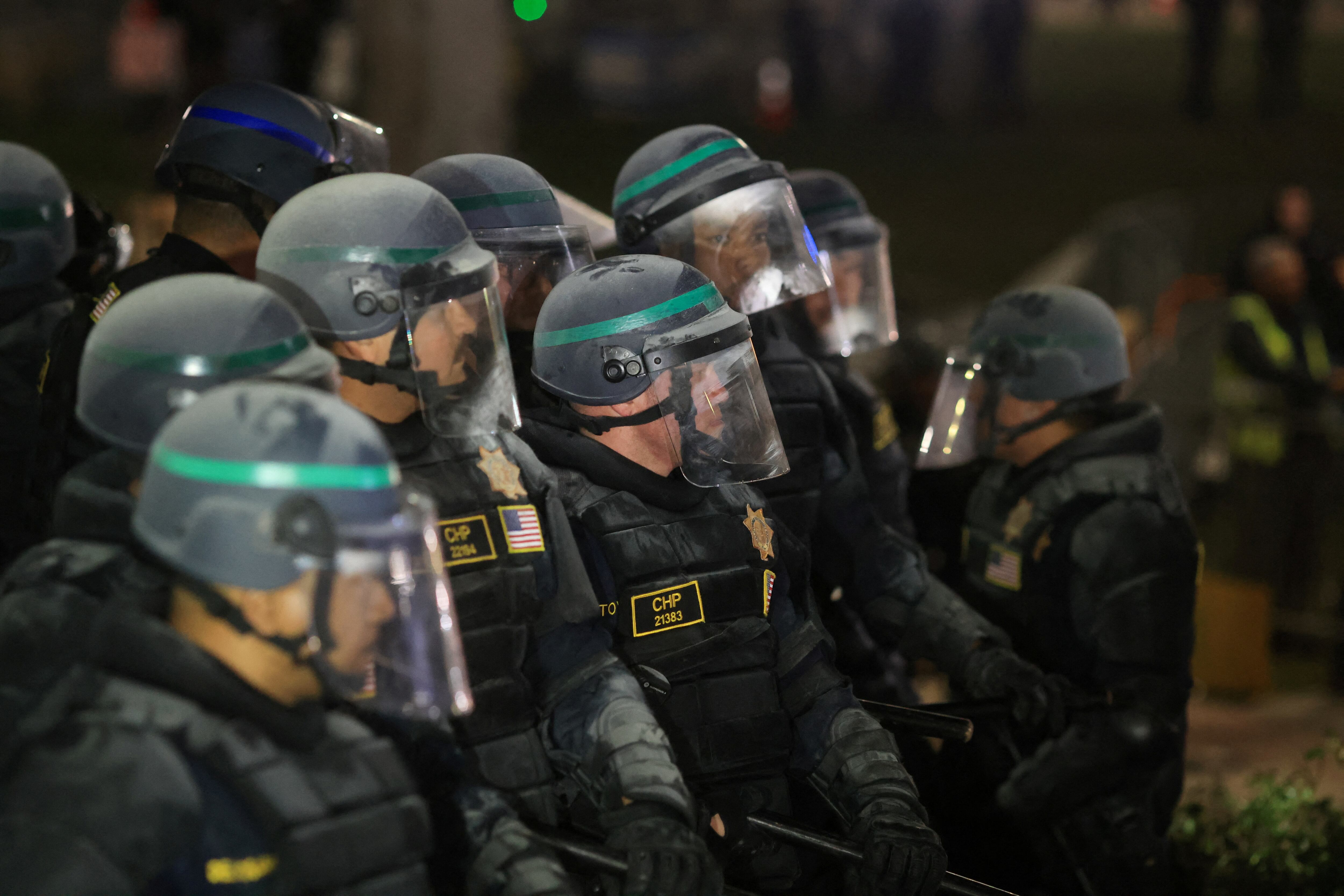 Policías antidisturbios, rociados con polvo para extinguir incendios, aguardan en formación durante la operación de desalojo de la UCLA este jueves. 