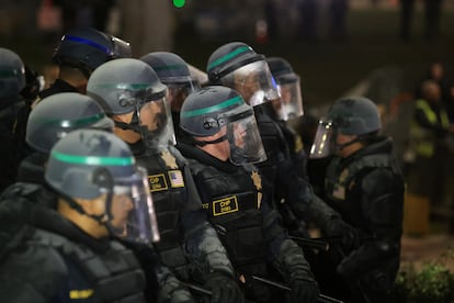 Policías antidisturbios, rociados con polvo para extinguir incendios, aguardan en formación durante la operación de desalojo de la UCLA este jueves. 