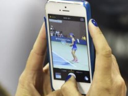 Una asistente al US Open de tenis hace una foto con un iPhone