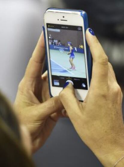 Una asistente al US Open de tenis hace una foto con un iPhone