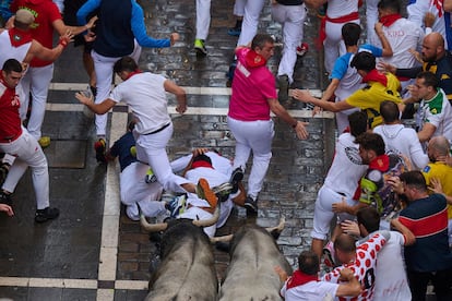 Un grupo de corredores cae al paso de la manada de los toros de José Escolar en el sexto encierro.