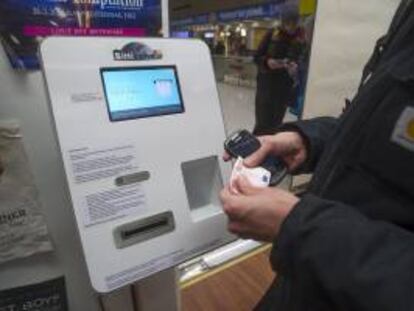 Una persona introduce un billete en un cajero automático que dispensa bitcoines, en una tienda de discos de Helsinki (Finlandia). EFE/Archivo