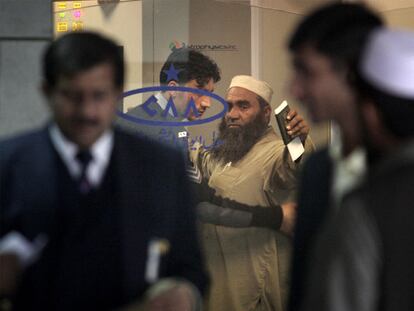 Un guardia de seguridad cachea a un pasajero en el aeropuerto de Islamabad (Pakistán).