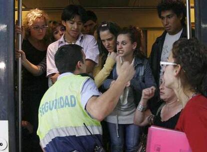 Un grupo de pasajeros pide explicaciones a un vigilante de seguridad de la estación de Sants.