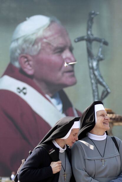 Dos monjas pasan ante un retrato gigante de Juan Pablo II en la plaza de San Pedro.