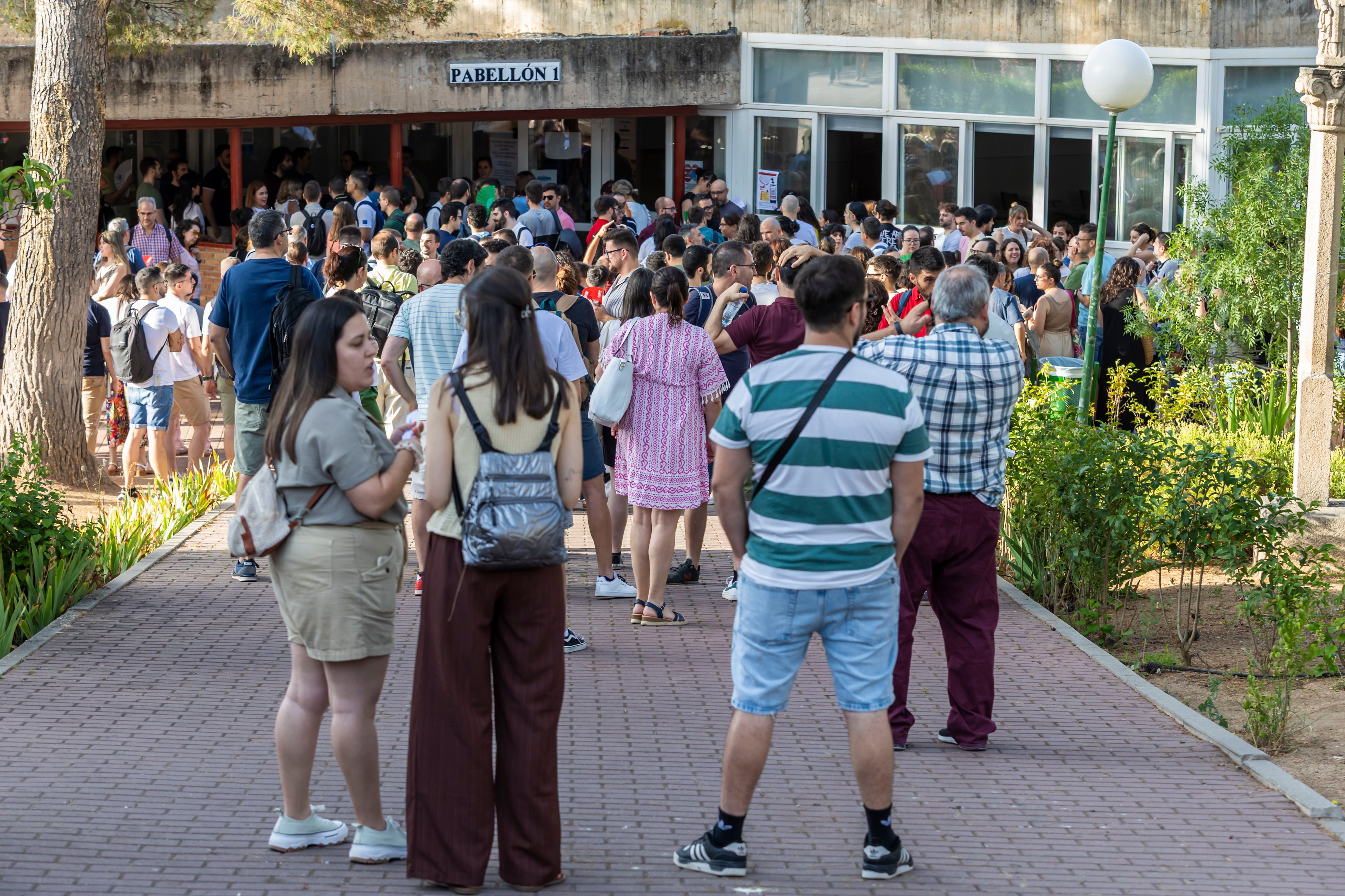 Decenas de aspirantes esperan al inicio de las oposiciones docentes en el instituto público Universidad Laboral de Toledo, en junio.